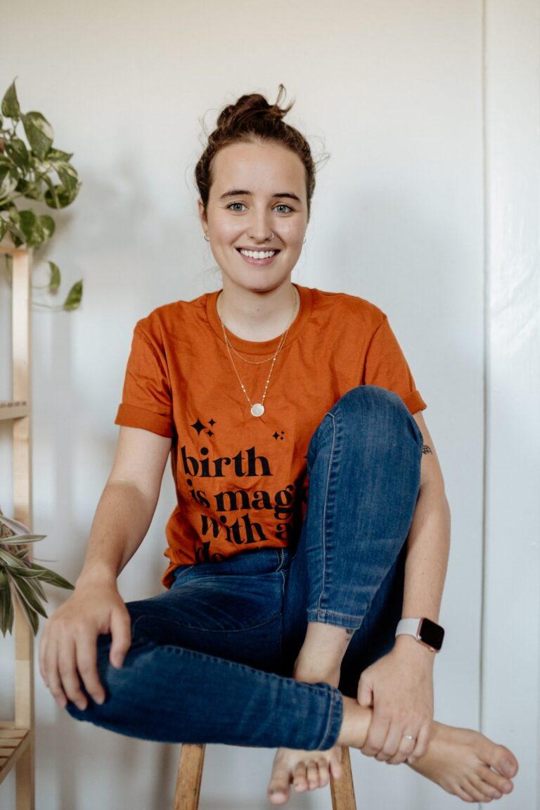 Kaëlla, doula in Gatineau, smiling and sitting on a stool